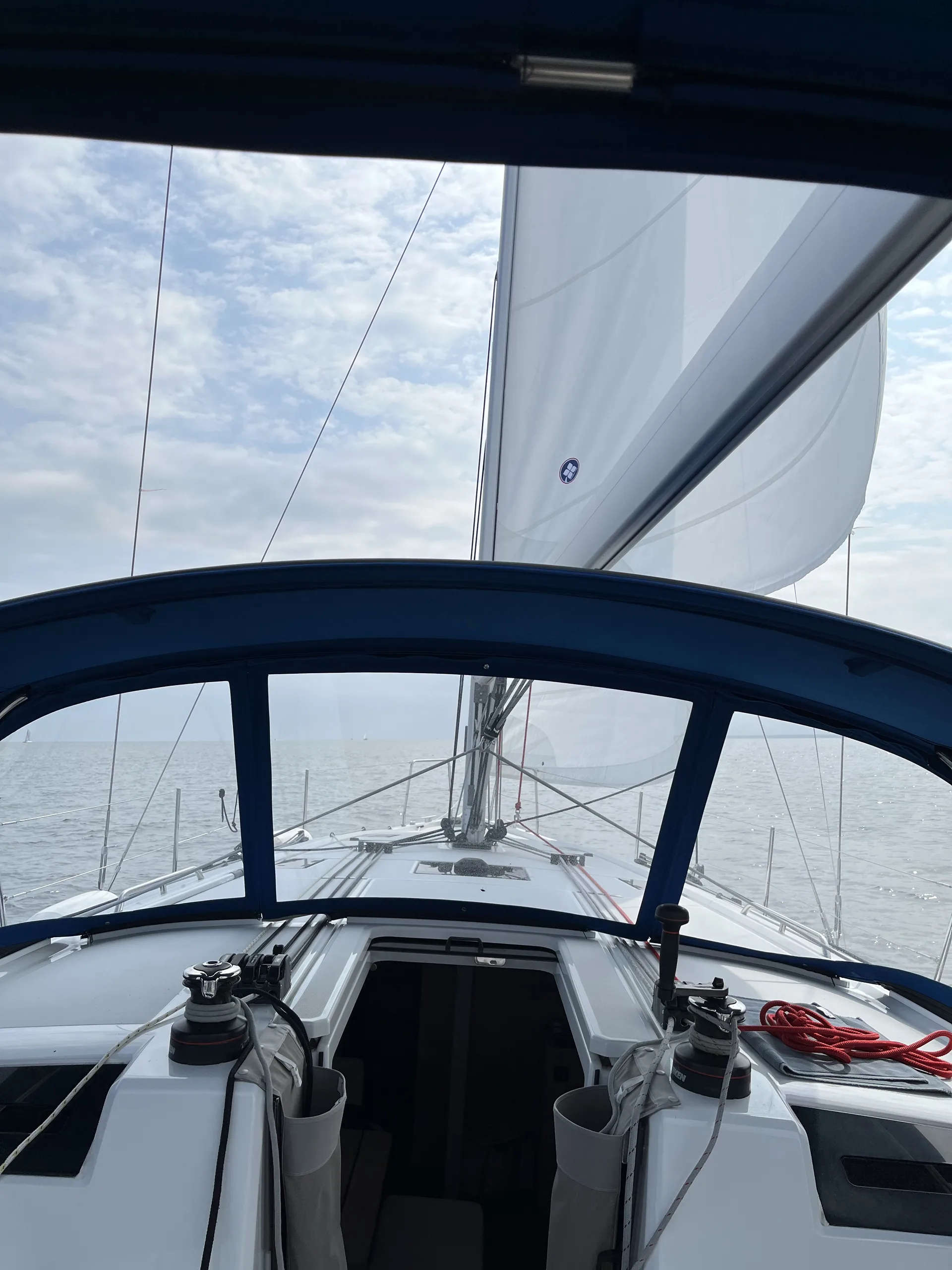 View forward from the cockpit of Zut Alors while sailing under a bright sky.